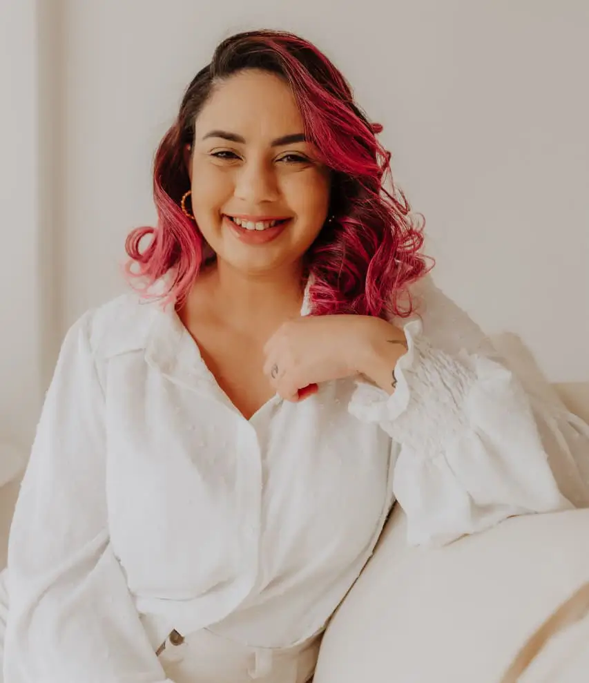 Psicóloga Jéssica de Mattos sorrindo de forma acolhedora em um ambiente de consultório, representando o atendimento de psicoterapia online focado em ACT e ansiedade.